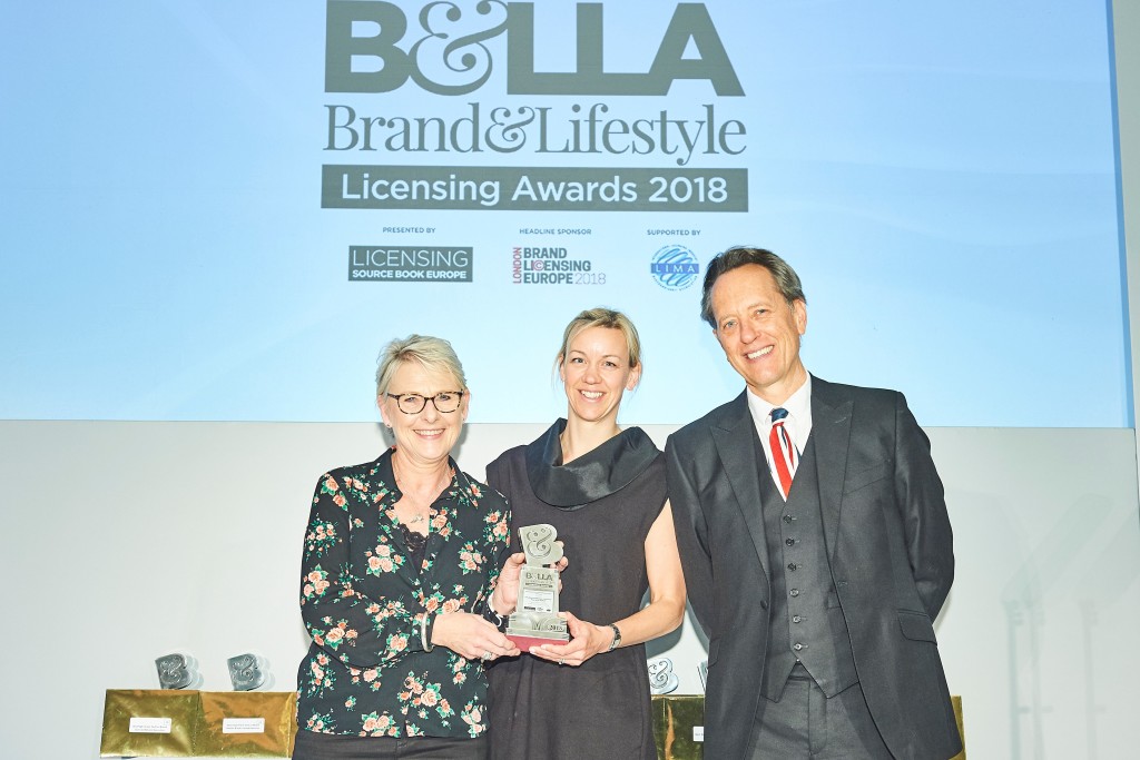 Above: Shown at last year’s awards, Susy Smith, (left), group editorial director of Hearst Magazines, presented a B&LLA’s trophy to Emma Puzey, licensing manager at Wild & Wolf, as winners of the Best Brand Licensed Gifting Product or Range category.The event was compered by actor Richard E. Grant (right).