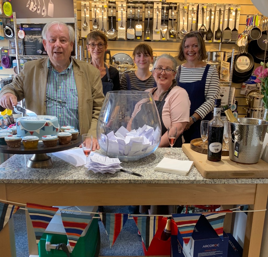 bove: T&G’s Patrick Gardner is pictured cutting the centenary cake with Glanville’s Rosie Hamm and some of the team. Patrick also helped to draw the winning raffle tickets.