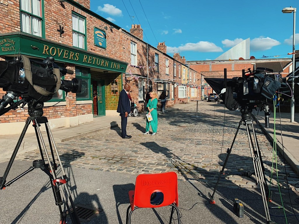 Above: Emily Coxhead, creator of the Happy News, was filmed on the cobbles of Coronation Street as part of the Granada Reports programme and was also interviewed by Zoe Ball on her BBC Radio 2 Breakfast Show.