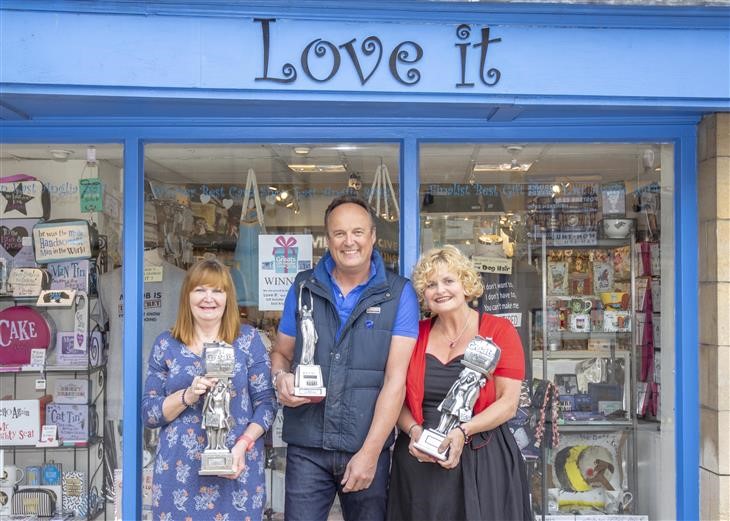 Above: Amanda and Will Oscroft, (centre and right), co-owners of Love It, Bury St Edmunds, are shown outside their Stamford shop with two Greats trophies, as well as a Retas award.  