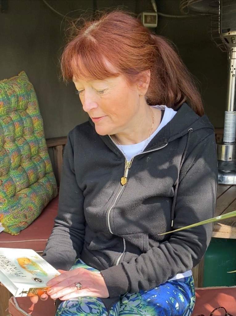 Above: Jo Webber in her garden reading a Jo-A-Story bedtime tale to her young Instagram followers.