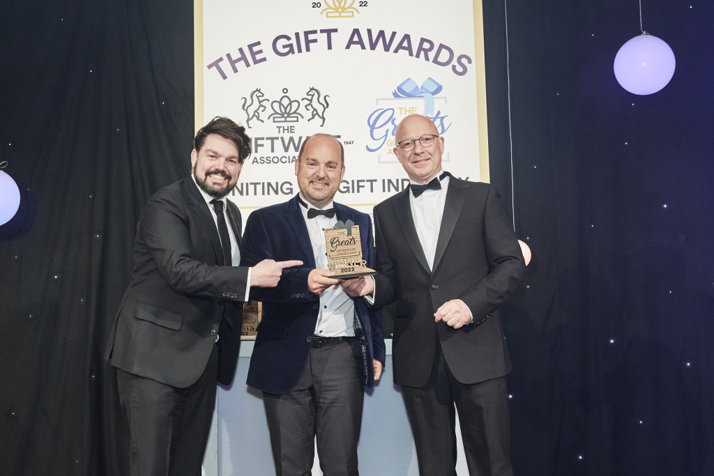 Above: Phil Verrills, (right) sales director at Gift Republic, sponsor of the Independent Gift Retailer of the Year – London, South, South East & East Anglia category, presented the winning Greats trophy to Greg Rose, co-owner of Maybugs. Comedian and compere Charlie Baker is shown on the left.