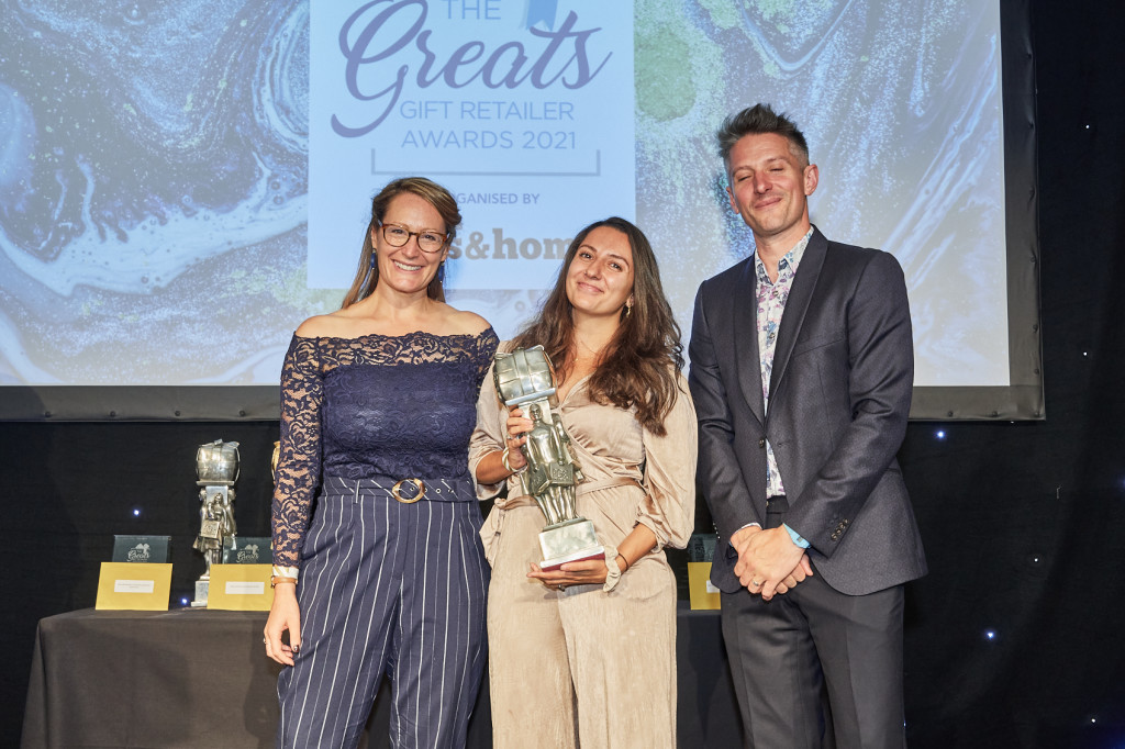 Above: As winner of The Greats Best Multiple Gift Retailer category in 2021, Priya Aurora-Crowe was presented with her Greats trophy by Helen Mansell-Stopher, (left) founder of Products of Change, category sponsor. On the right is Awards compere Stuart Goldsmith.